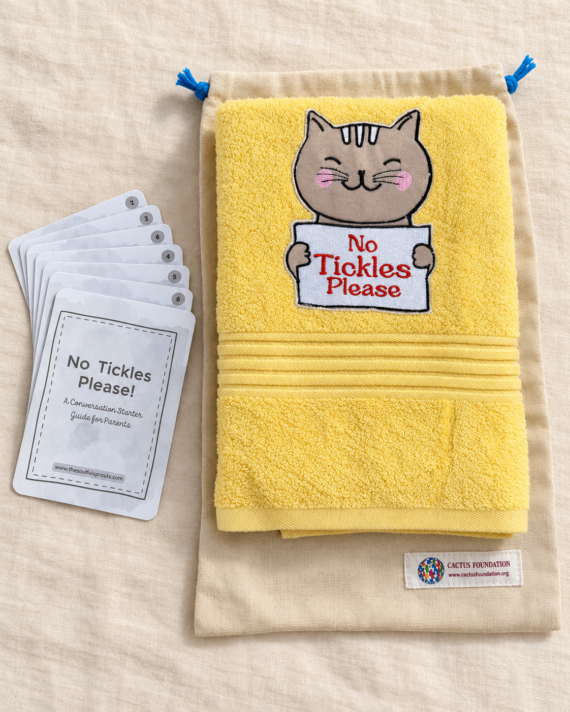 Yellow towel photographed with conversation guide cards and a drawstring bag