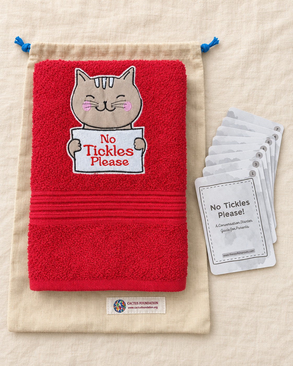 Red towel photographed with conversation guide cards and a drawstring bag